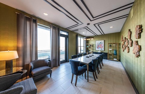 A dining room with a long table and chairs.