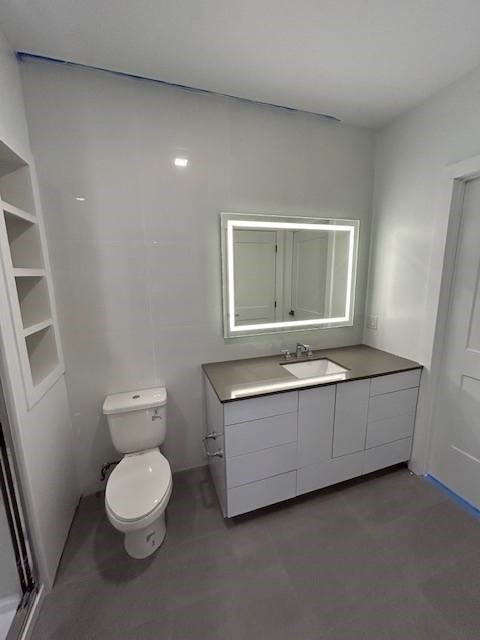 A white toilet sits next to a sink in a bathroom.