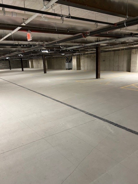 A spacious, empty parking garage with concrete floors and walls.