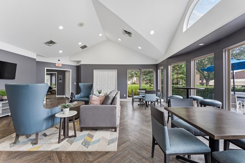 A modern living room with a blue armchair and a wooden dining table.
