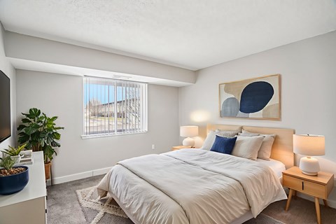 A bedroom with a large bed and a painting on the wall.