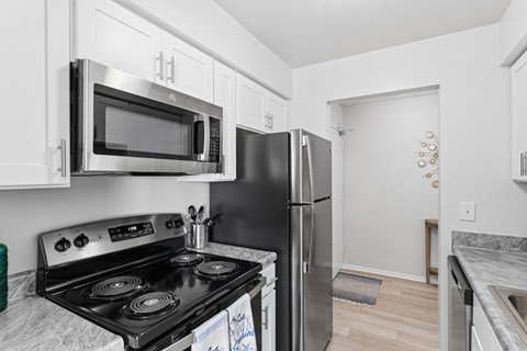 A kitchen with a black stove top oven and a black refrigerator.