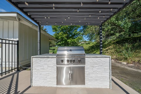 A stainless steel outdoor kitchen with a grill and sink.