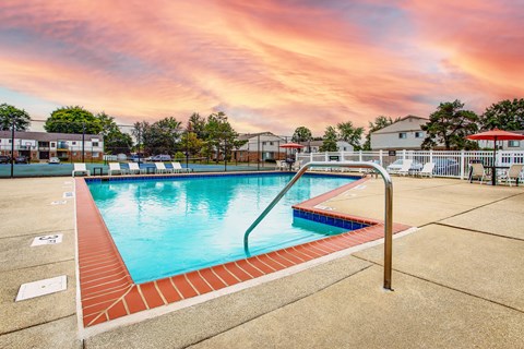 Outdoor swimming pool with diving board at sunset at Fordham Green Apartments, Canton, MI