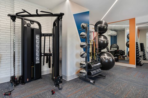 A gym with a weight machine and a mirror.