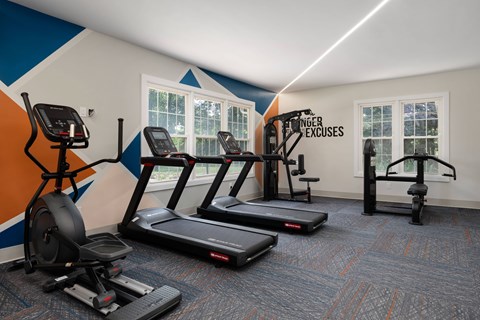 A gym with treadmills, elliptical machines, and a stationary bike.