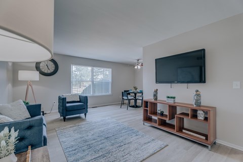 A living room with a blue couch and a wooden shelf.