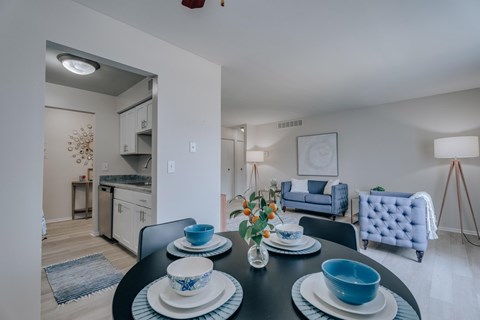 A dining table set with blue and white dishes and a vase of flowers.