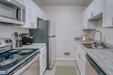 A kitchen with a blue stove top and white cabinets.