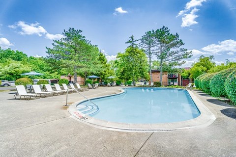 Outdoor swimming pool with sundeck and lounge chairs at Hidden Valley Apartments, Southfield, Michigan