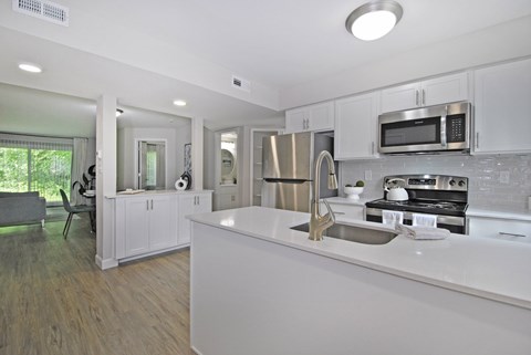 A modern kitchen with white cabinets and stainless steel appliances.