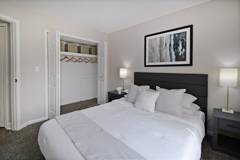 Bedroom with walk-in closet and modern furnishings at Bloomfield Villas Apartments, Auburn Hills, MI 48362