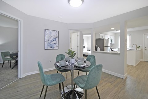 Dining area with teal chairs and open kitchen at Bloomfield Villas Apartments, Auburn Hills, 48362