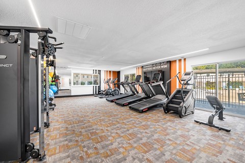 Fitness center with cardio equipment and weight machines at Cambridge on Ford Apartments, Canton