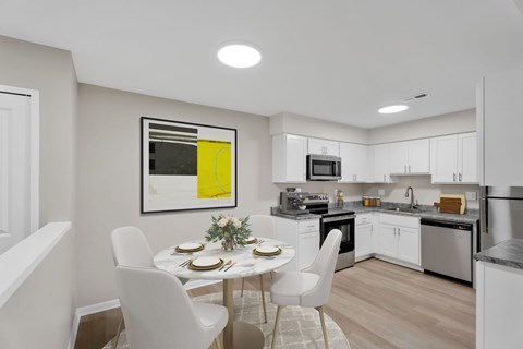 A modern kitchen with a dining table set for two.