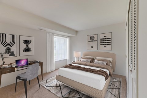 Bedroom with desk workspace and neutral decor at Deerfield Woods Apartments, Michigan, 48152