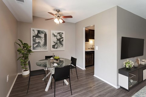Dining area with glass table and ceiling fan at Deerfield Woods Apartments, Livonia, MI 48152