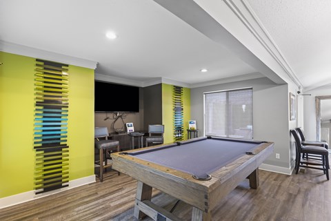 A pool table in a room with a yellow wall.