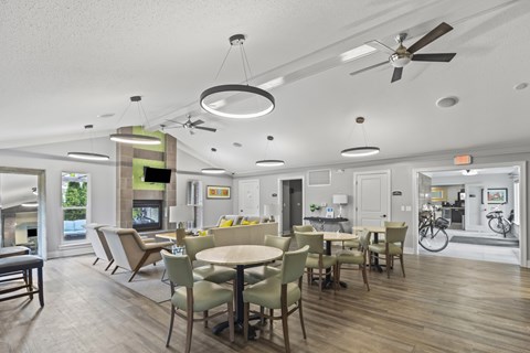 A modern dining room with a wooden floor and white walls.