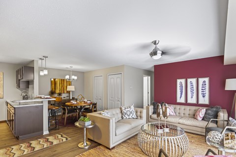 A living room with a white couch and a dining table.