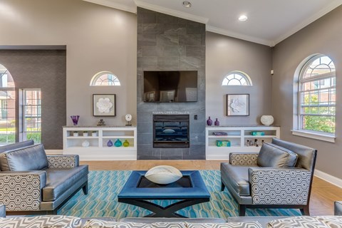 Clubhouse lounge with fireplace and seating at Kingsley Apartments, Sterling Heights, 48312