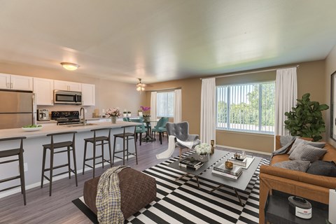 A well-lit kitchen with a bar area and a dining table set for two.