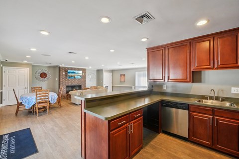 A kitchen with wooden cabinets and a stainless steel dishwasher.