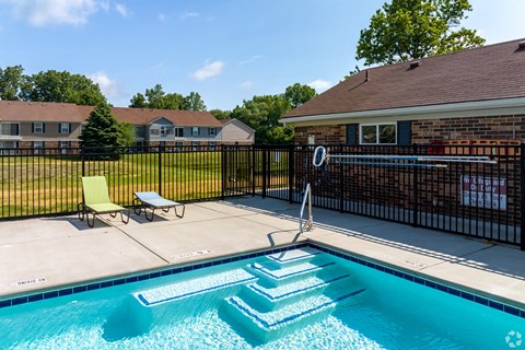 A pool with a slide and a fence.