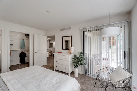 Bedroom with patio access and walk-in closet at Valley Ranch Apartments, Ann Arbor, 48108