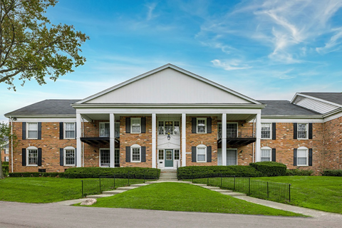 A large brick house with a white front door and windows.