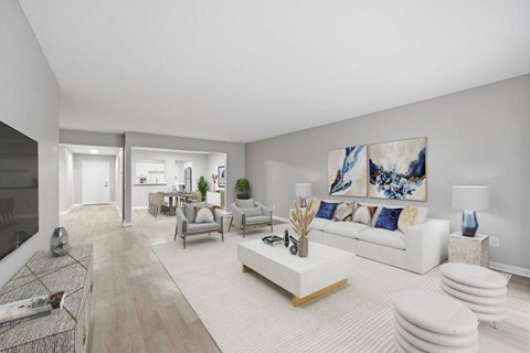 A modern living room with a white sofa and a large painting on the wall.
