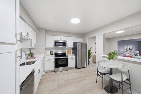 A modern kitchen with white cabinets and stainless steel appliances.