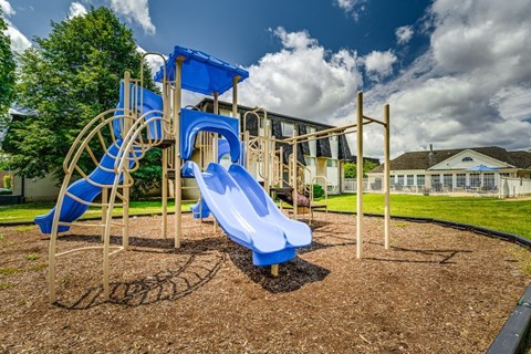 Playground with blue slides and climbing structures at Hampton Court Apartments, Westland, Michigan