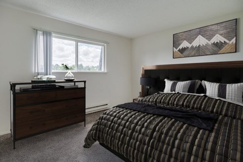 Bedroom with wood furniture and mountain artwork at Hampton Court Apartments, Michigan