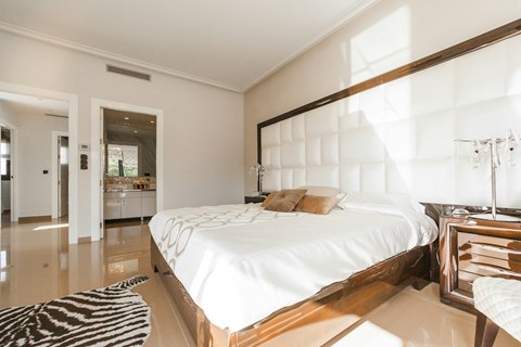 A bedroom with a large bed and a zebra rug on the floor.