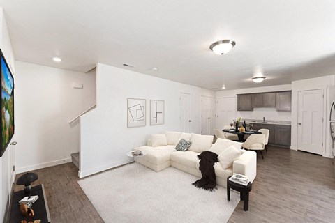 A white couch with a black cat on it sits in a living room.