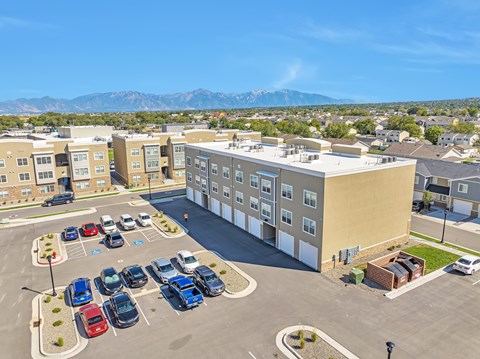 A parking lot with cars and a building in the background.