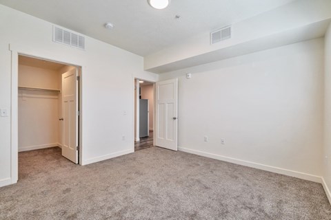 A spacious room with carpeted floor and white walls.