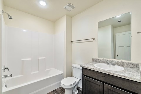 A white bathroom with a toilet, sink, and bathtub.