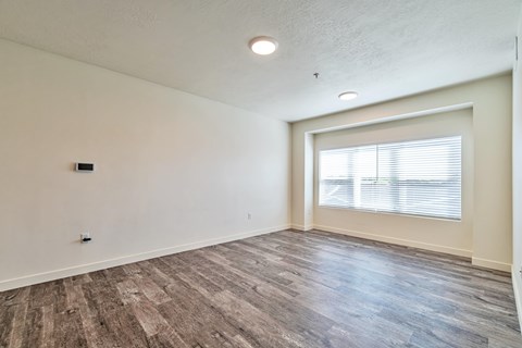 A room with a window and wooden flooring.