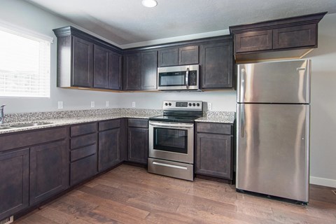 A kitchen with dark wood cabinets and stainless steel appliances.