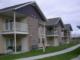 an apartment building with two balconies and a sidewalk