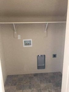 a bathroom with a urinal and a picture on the wall