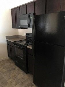 a kitchen with a stove a refrigerator and a microwave