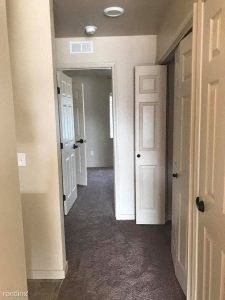a hallway with white doors and a gray floor