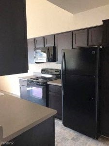 a kitchen with a stove a refrigerator and a microwave