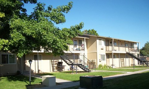 Apartment complex with green trees in front.