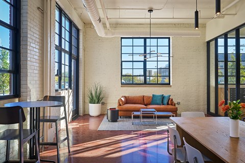 A living room with a brown couch and a wooden table.