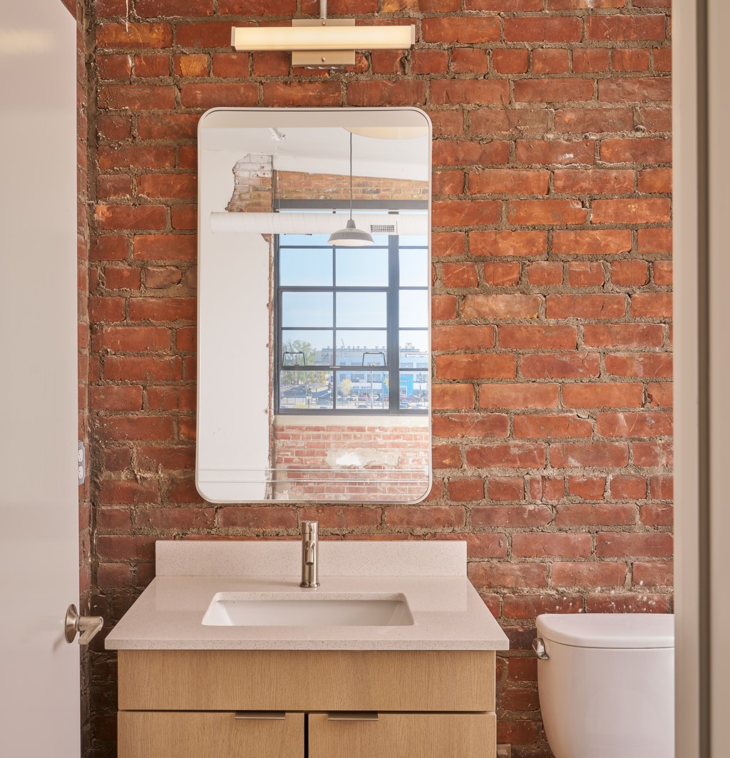 A bathroom with a white sink and a mirror above it.