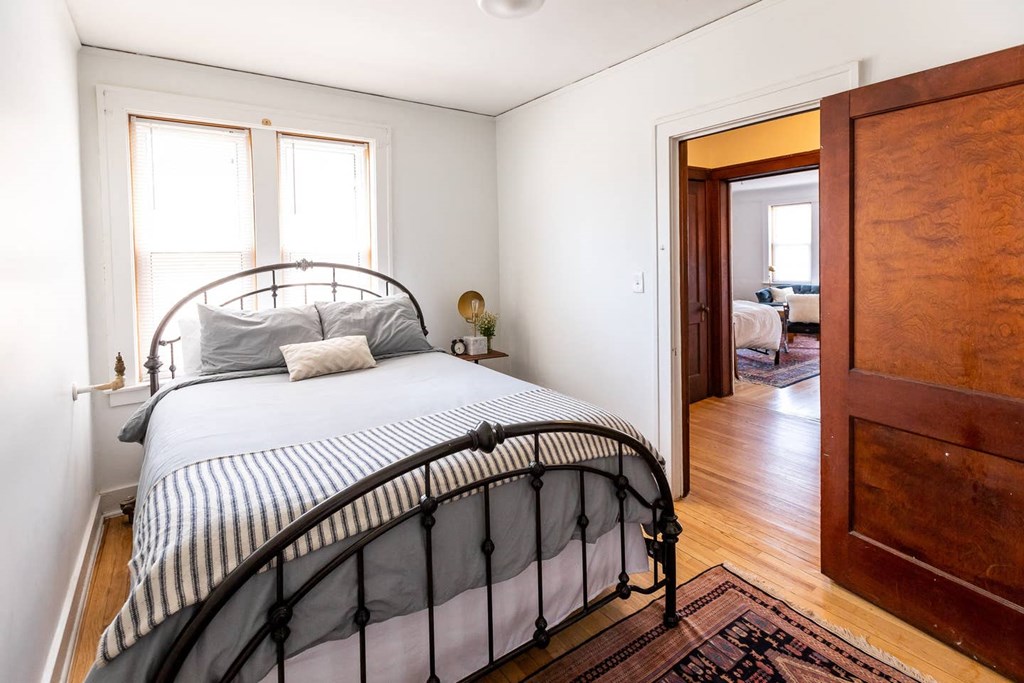 A bedroom with a bed and a wooden door.